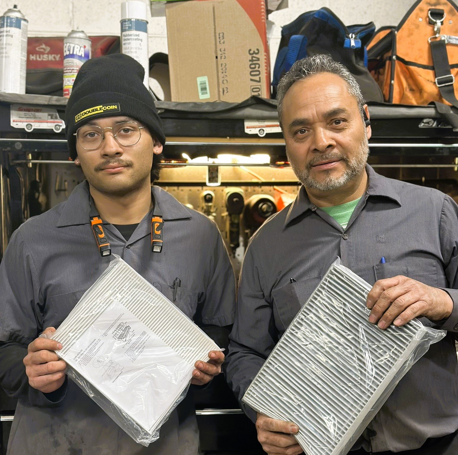 Owner and technician displaying new packaged air filters